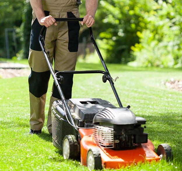 jardinier paysagiste entrain de tondre une pelouse